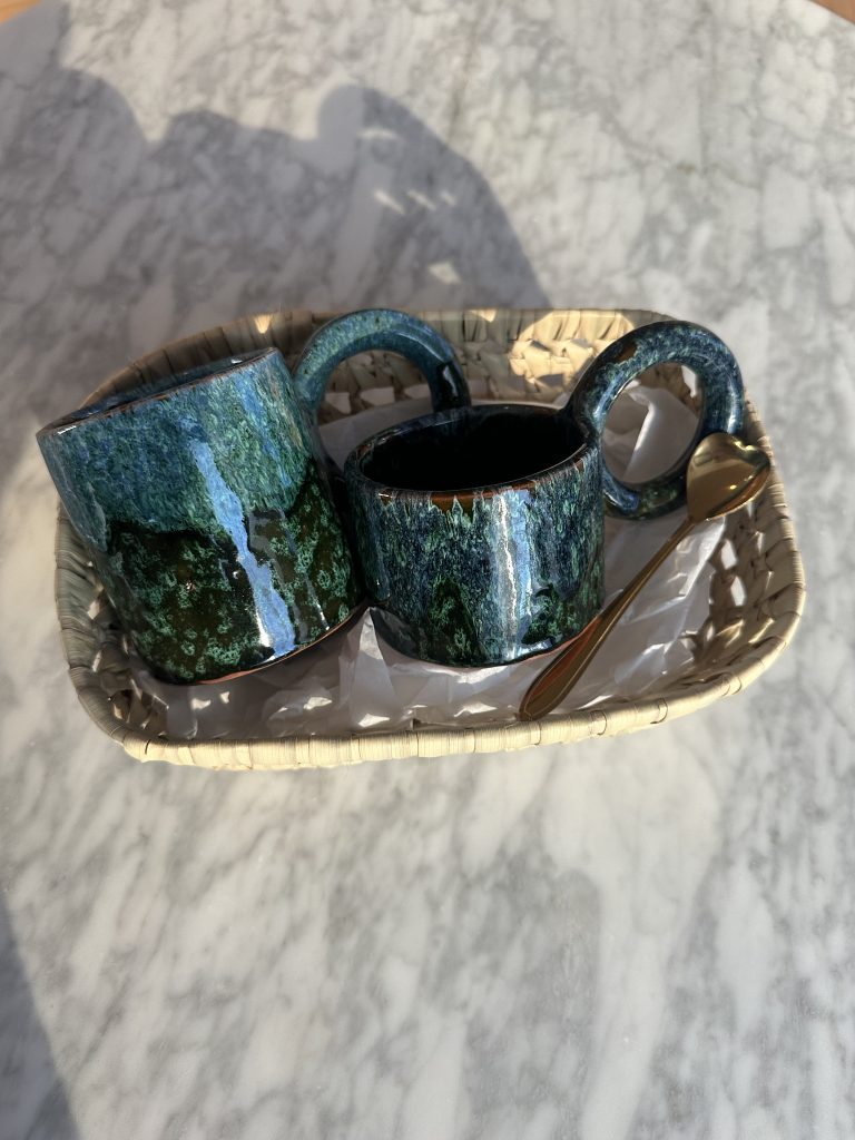 deux tasses de taille differentes avec une cuillere doré en forme de coeur